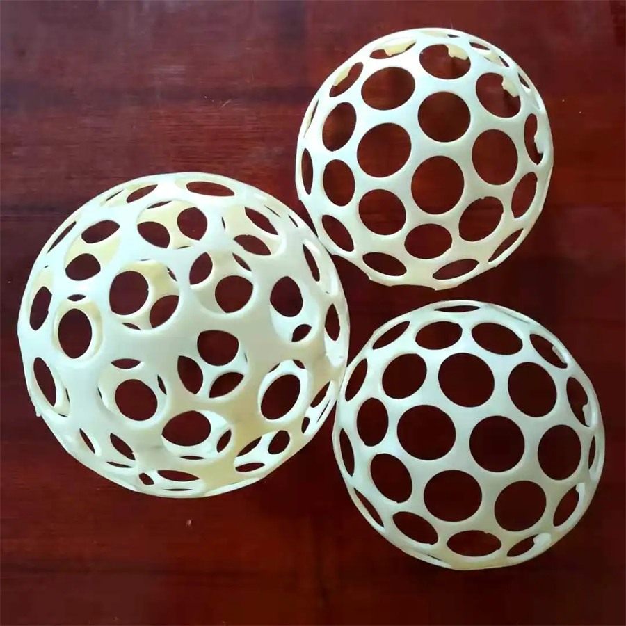 Three ABS flocculation balls on a dark wooden surface
