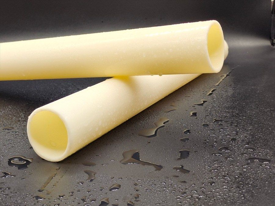 ABS pipes on a wet surface, two pipe ends in close-up with water droplets