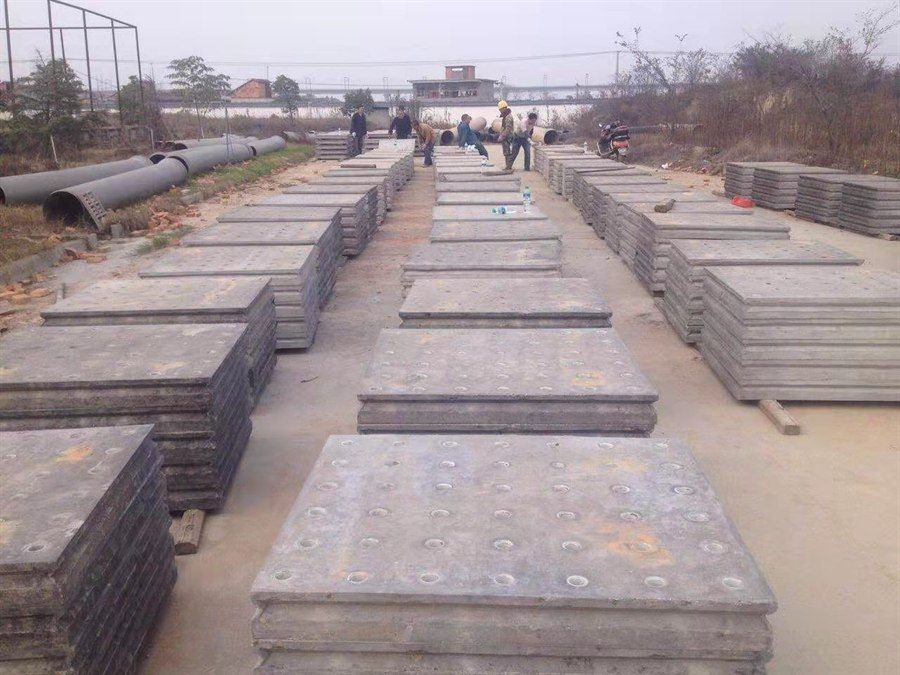 Rows of concrete filter plates in the workshop with workers