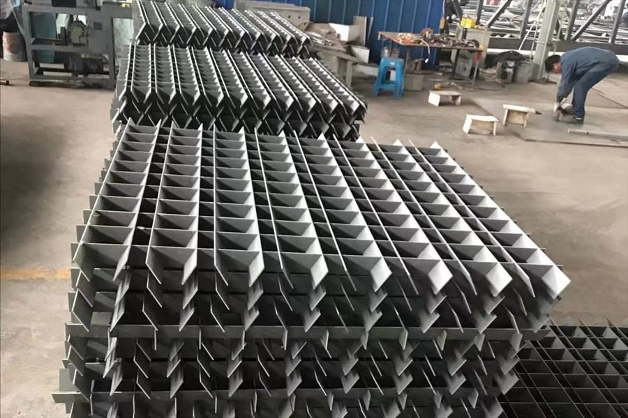 Dark grey flocculation grid modules stacked in the workshop