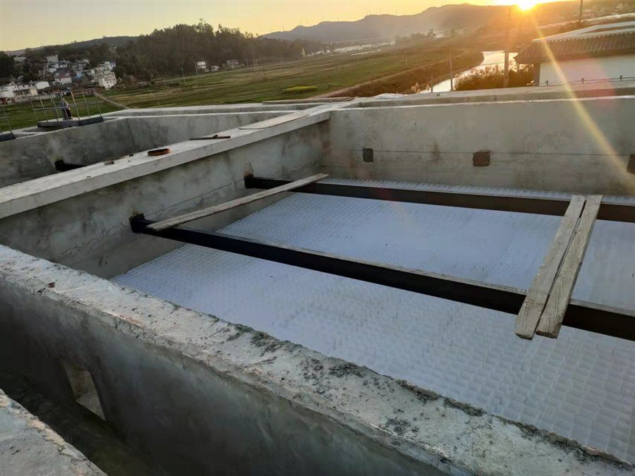 Inclined plate media under support beams in a basin