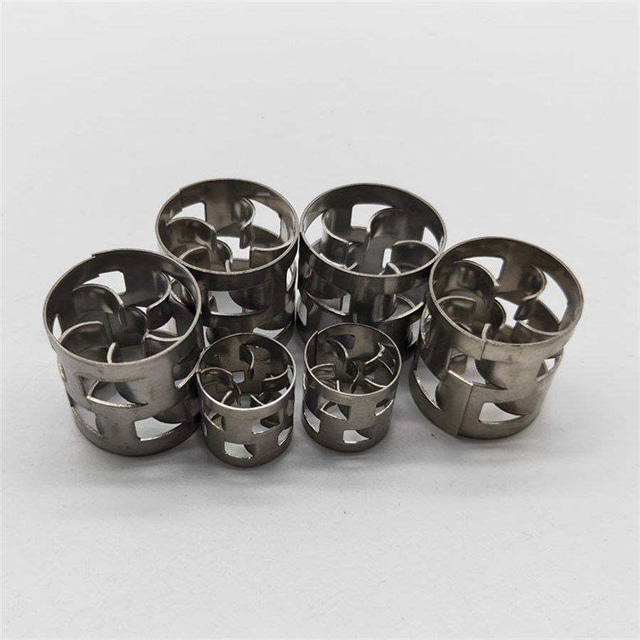 Six stainless steel Pall rings arranged in two rows on a light background