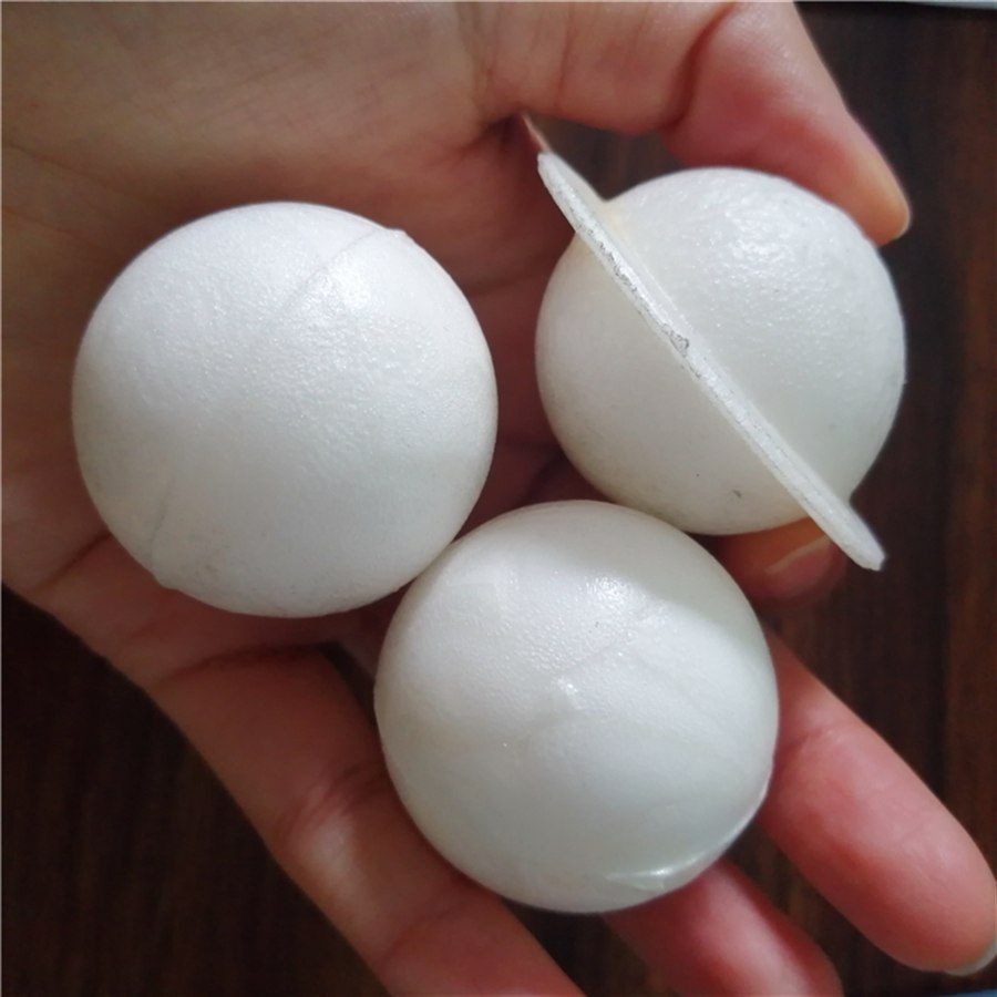 Foamed PP cover balls held in hand, one showing the internal disc