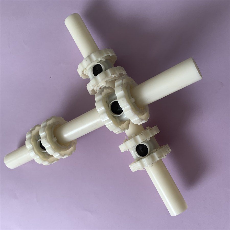 Four-way single-orifice membrane aerator assembly on a purple background