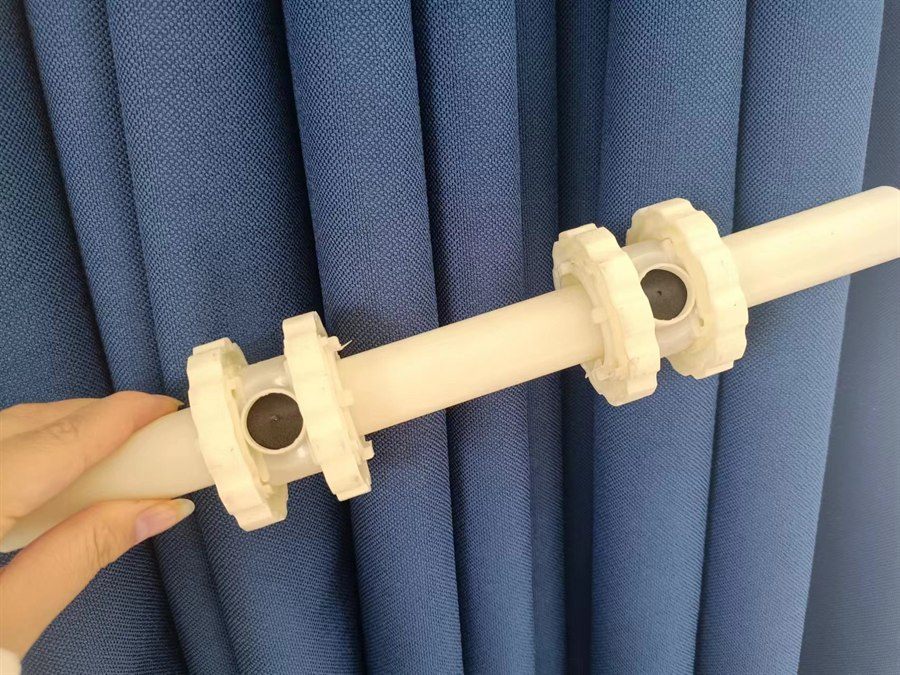 Aerator body held in hand, showing two membrane stations on the pipe