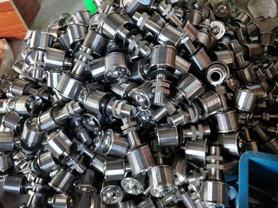 Stainless steel drain caps piled in bulk at the factory